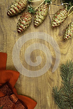 Christmas card, wooden background with snow fir tree, pine cones, red bows, View with copy space