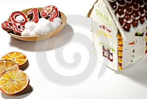 Christmas card: on a wooden plate are red ginger cookies in the shape of numbers 2019 and white round snowflakes