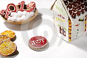 Christmas card: on a wooden plate are red ginger cookies in the shape of numbers 2019 and white round snowflakes