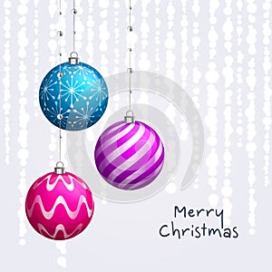 Christmas card. Xmas balls hanging on ribbons with pearls.