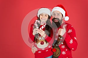 Christmas Carol. Father and daughter with candy canes christmas decorations. Family holiday. Santa claus family look