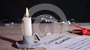 Christmas carol song sheet with candle and gift