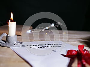 Christmas carol song sheet with candle and gift