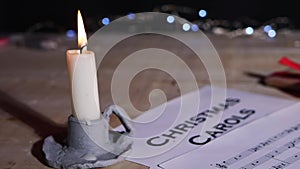 Christmas carol song sheet with candle and gift