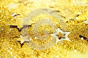 Christmas celebration. Abstract background for new year party. Patter of gold stars with lights, bokeh. Golden glitter stars on