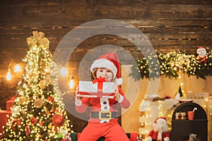 Christmas Celebration holiday. Cute little child near Christmas tree. Happy little child dressed in winter clothing