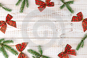 Christmas checkered bows with green fir tree branches making a border or frame for your text, creative minimalistic composition on