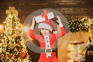 Christmas child. Cute little child near Christmas tree. Happy little child dressed in winter clothing think about Santa