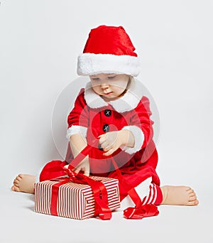 Christmas child girl in Santa hat opening Xmas gift box