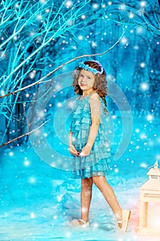 Christmas child girl on winter tree background, snow, snowflakes