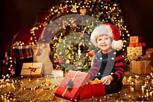 Christmas Child Open Present under Xmas Tree, Happy Baby Boy photo
