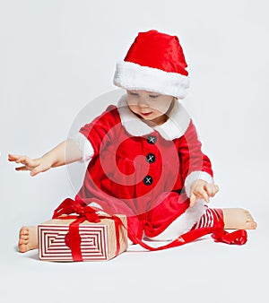 Christmas child in Santa hat opening Christmas gift box