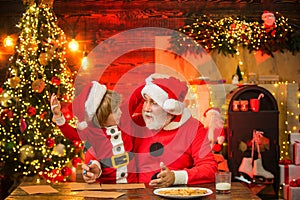 Christmas Child son and father Write Letter to Santa Claus. Child boy and grandfather writing christmas letter to Santa