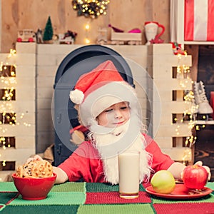 Christmas child. Thanksgiving day and Christmas. Santa Claus. Santa boy child eating cookies and drinking milk.
