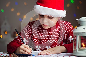 Christmas child writing letter to Santa Claus letter in red hat