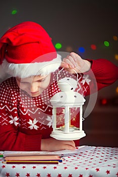 Christmas child writing letter to Santa Claus letter in red hat