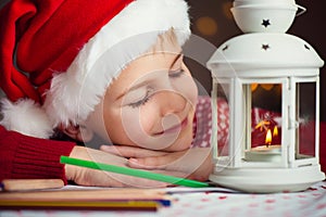 Christmas child writing letter to Santa in red hat