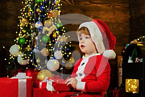 Christmas children. Christmas child holding a red gift box. Christmas kids - happiness concept. Cheerful cute child