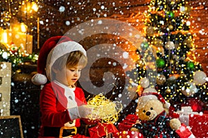 Christmas childs in snow. New year garland lights. Christmas time. Happy little child play with xmas decorations. Lovely