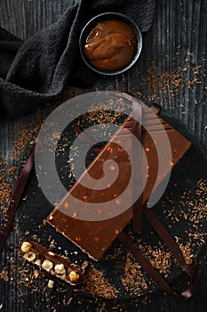 Christmas chocolate turron and hazelnuts on a dark background. Made with toasted hazelnuts and chocolate. Christmas dessert. Verti