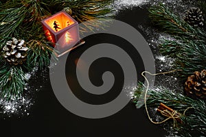 Christmas, christmas tree, candle, snow, cones and cinnamon sticks on black background