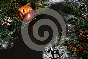 Christmas, christmas tree, candle, snow, cones and cinnamon sticks on black background