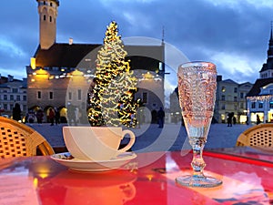 Christmas in the city  holiday New year  evening light  ,cup of coffee on table top view and blue glass of wine  in street cafe