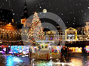 Christmas  the city  holiday New year night  light  and snowflakes fall  in Tallinn old town square Christmas tree decoration