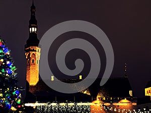 Christmas city market place in Tallinn town Hall Square fireworks , Illuminated tree,night light blurred ,people walking ,New year