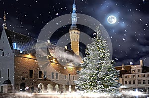 Christmas city town hall square  decorated and iluminated street lamp blurred light houses with evening snowy weather snow