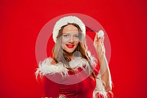 Christmas Close up portrait of beautiful girl wearing santa claus clothes, over red background