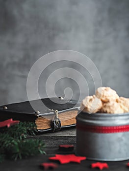 Christmas coconut meringue cookies in metal box and old bible on background