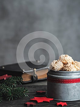 Christmas coconut meringue cookies in metal box and old bible on background