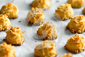 Christmas coconut puffs macaroon cookies on parchment paper on tray. Festive cozy home atmosphere. Holiday pastry baking