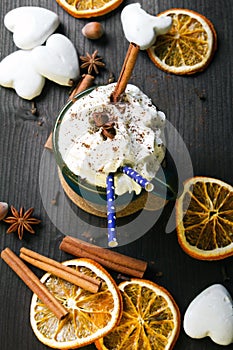 Christmas coffee cup with whipped cream, cinnamon, cocoa powder, anise, dried orange ang gingerbread cookies