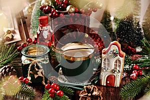Christmas coffee and gingerbread cookie on wooden table with festive decors