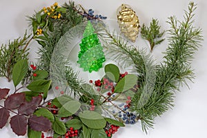 Christmas collage with Christmas tree surrounded by branches of evergreens on a white background