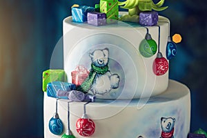 Christmas colorful three-Tiered cake decorated with drawings of Teddy bears, gift boxes and a green tree top