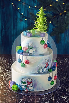 Christmas colorful three-Tiered cake decorated with drawings of Teddy bears, gift boxes and a green tree top