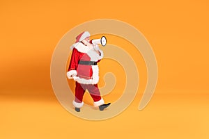 Christmas is coming ! Real Santa Claus shouting using megaphone over yellow studio background. Xmas sale, discount concept. Copy