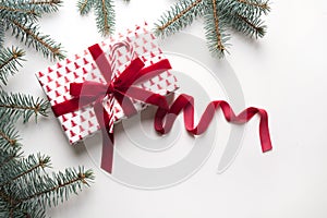 Christmas compisition with red gift and fir branches on white background. Greeting card. Winter holiday. Happy New Year. Space for