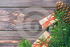 Christmas composition background. Christmas gift with pine cones and fir branches on wooden background. Flat lay, top view, copy