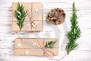 Christmas composition background. Christmas gift with pine cones and fir branches on wooden background. Flat lay, top view, copy