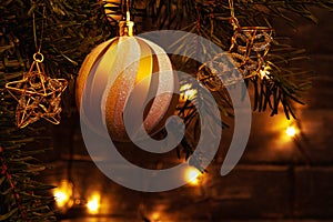 Christmas composition, ball and other decorations on the branches of a Christmas tree on a dark background with lights