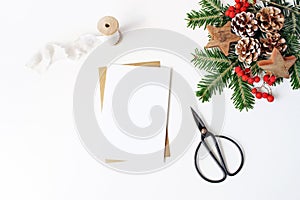 Christmas composition. Blank greeting card, envelope mock-up scene. Decorative corner. Pine cones, fir tree branches