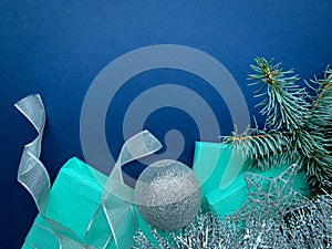 Christmas composition with blue gifts silver decorations on blue background.