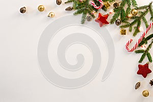 Christmas composition. The border is made of Christmas decoration toys, fir branches, mints on a white background. Flat lay, top v
