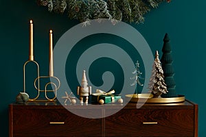 Christmas composition on brwon wooden commode with decoration, christmas tree, gifts and accessories in cozy home decor.