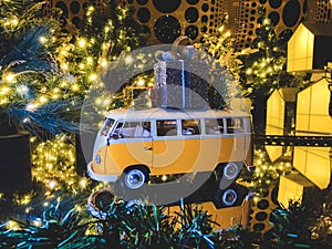 Christmas composition. Bus toy with gifts and the new year pine tree on the background