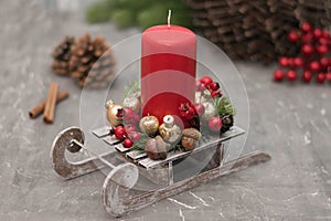 Christmas composition with candle in small sleigh